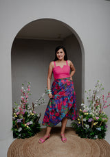 Front view of Back from Vacay Skirt Set featuring a pink V-neck top and asymmetrical ruffle skirt.