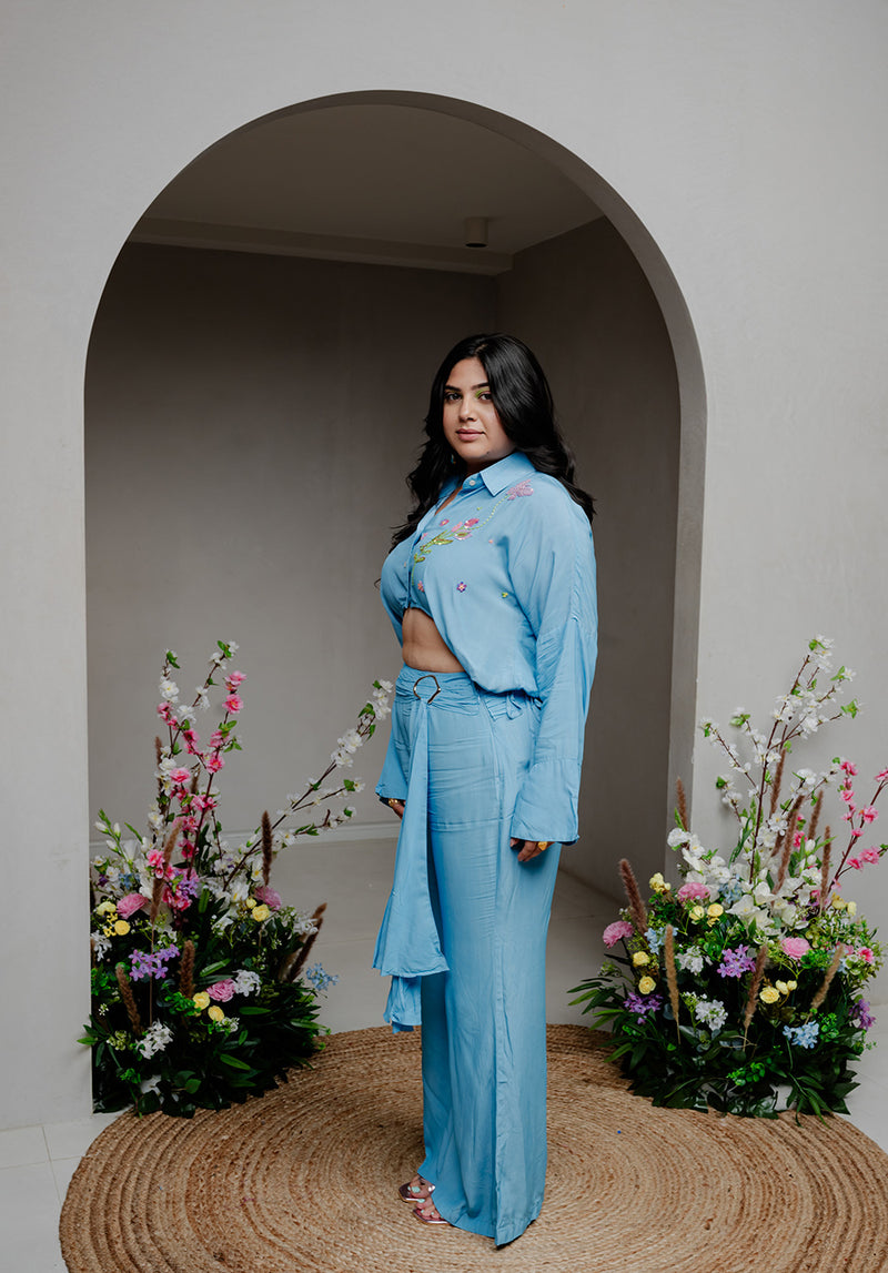 Side profile of the Balmy Coord Set, showcasing the elegant fit of the cropped embroidered shirt and high-waisted pants with a gathered belt.